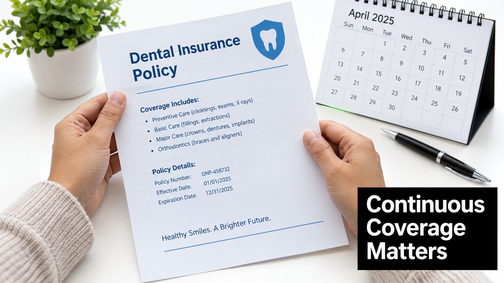 A person holds a dental insurance policy document next to a calendar and a pen on a desk.